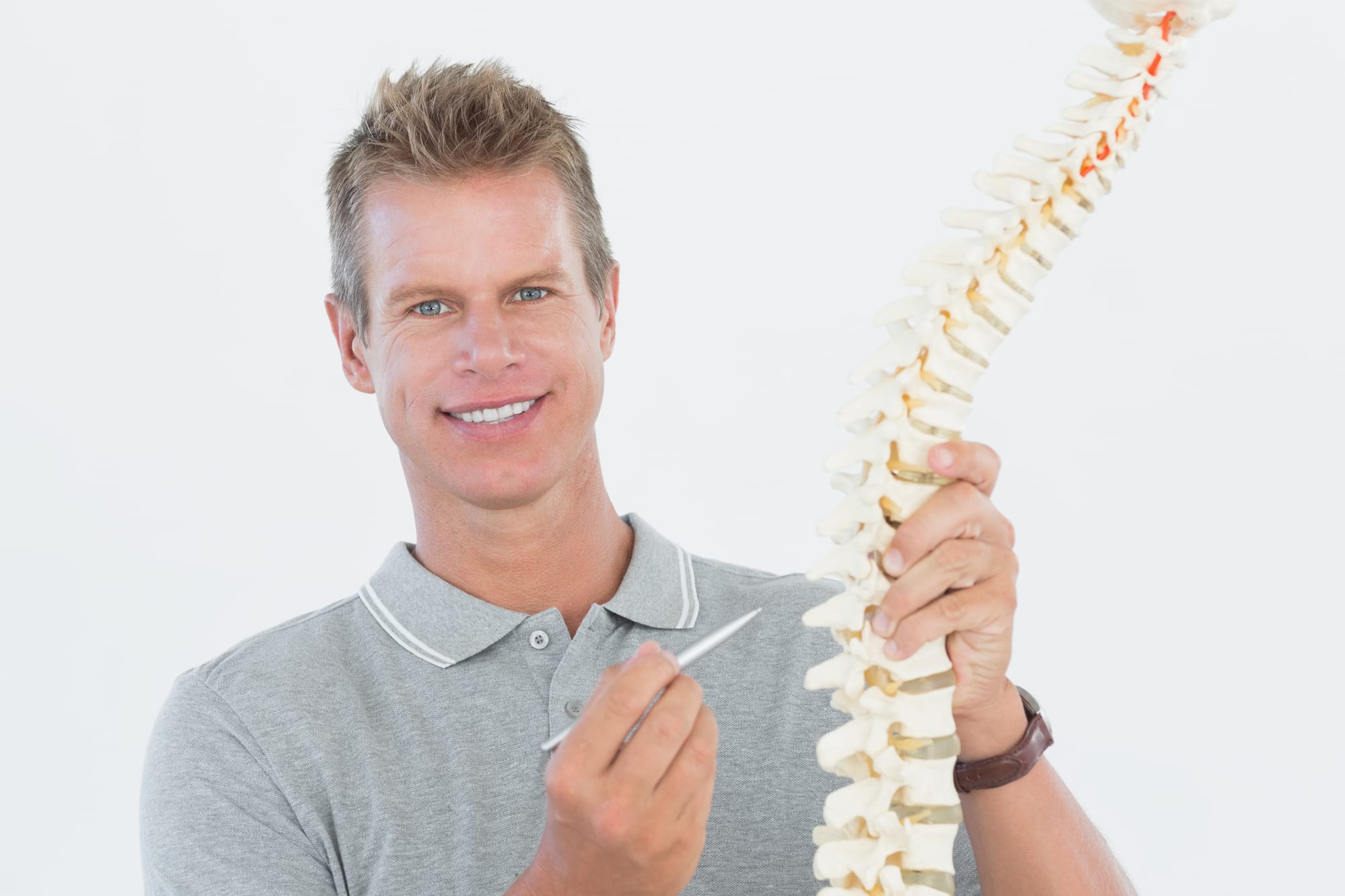 A medical professional displays a spine model
